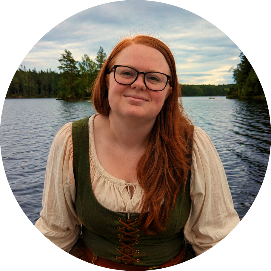 Elin Kindstrand, romance and romantasy story coach, beside a lake in Sweden